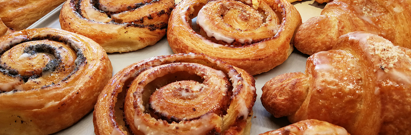 Franzbrötchen, Zimtschnecken und Croissants auf dem Blech