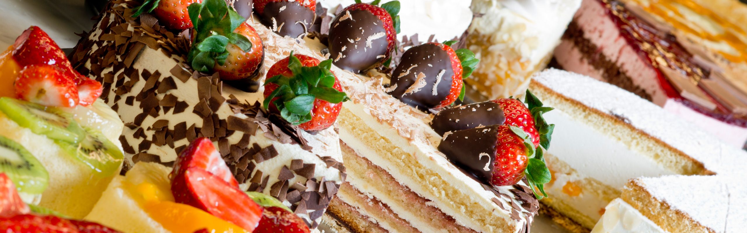Auswahl feiner Torten mit Erdbeeren, Schokolade und Früchten